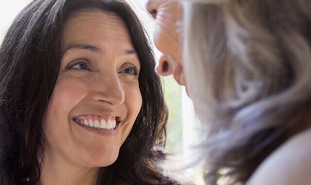 women smiling at each other with dentures 